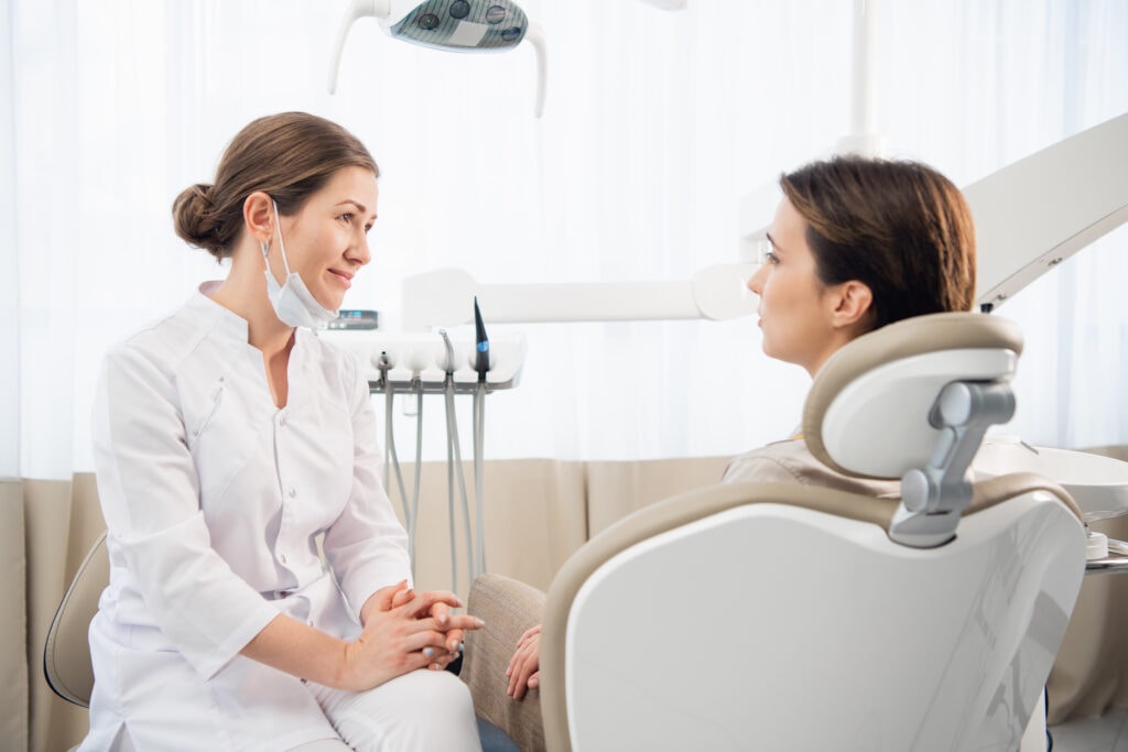 a closeup portrait of a female dentist consulting her patient. preventive medical annual check up. positive facial expression