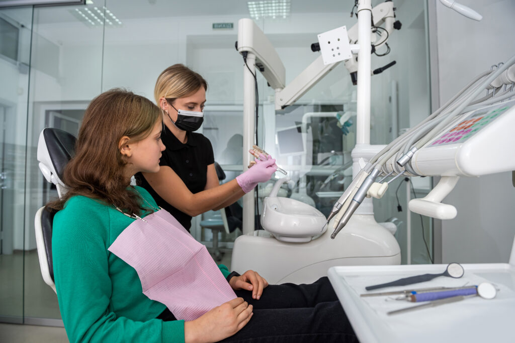 dentist showing how to brush your teeth on jaws model to patient in dental clinic